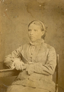 Молодая женщина за столом. фотография М. Хапалова в Ирбите, 1880-1900